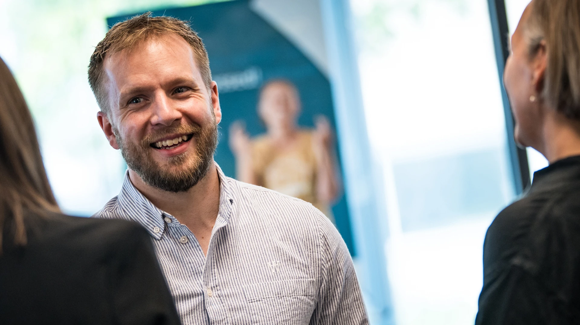 Smilende rådgiver taler med kunde.